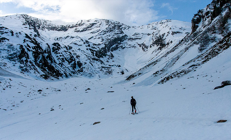 Vooral in het voorjaar bestaat het risico op natte sneeuwlawines wanneer de temperatuur in de loop van de dag stijgt. Toerskiër alleen in de besneeuwde bergen