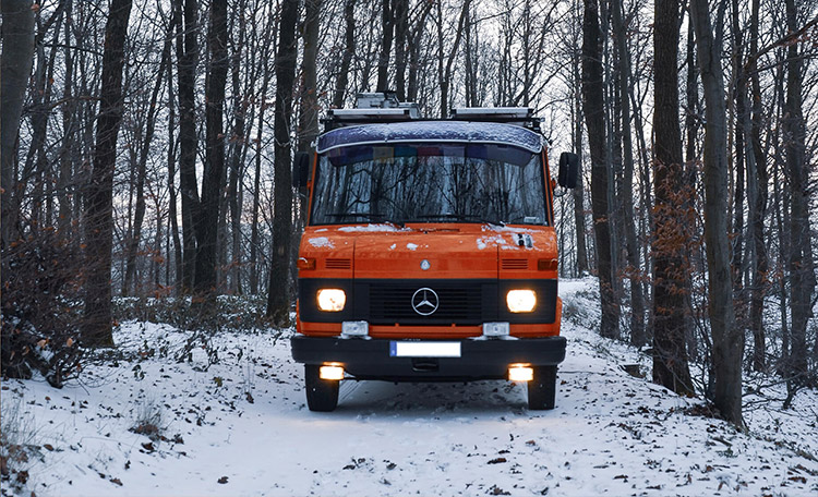Rode camper in besneeuwd landschap