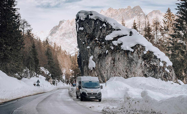 Camper op een besneeuwde weg in de bergen.